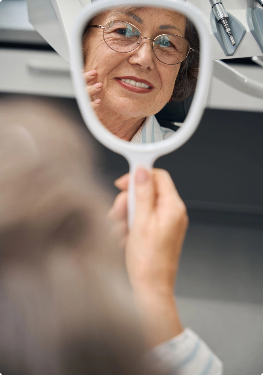 Lady looking at mirror dental clinic