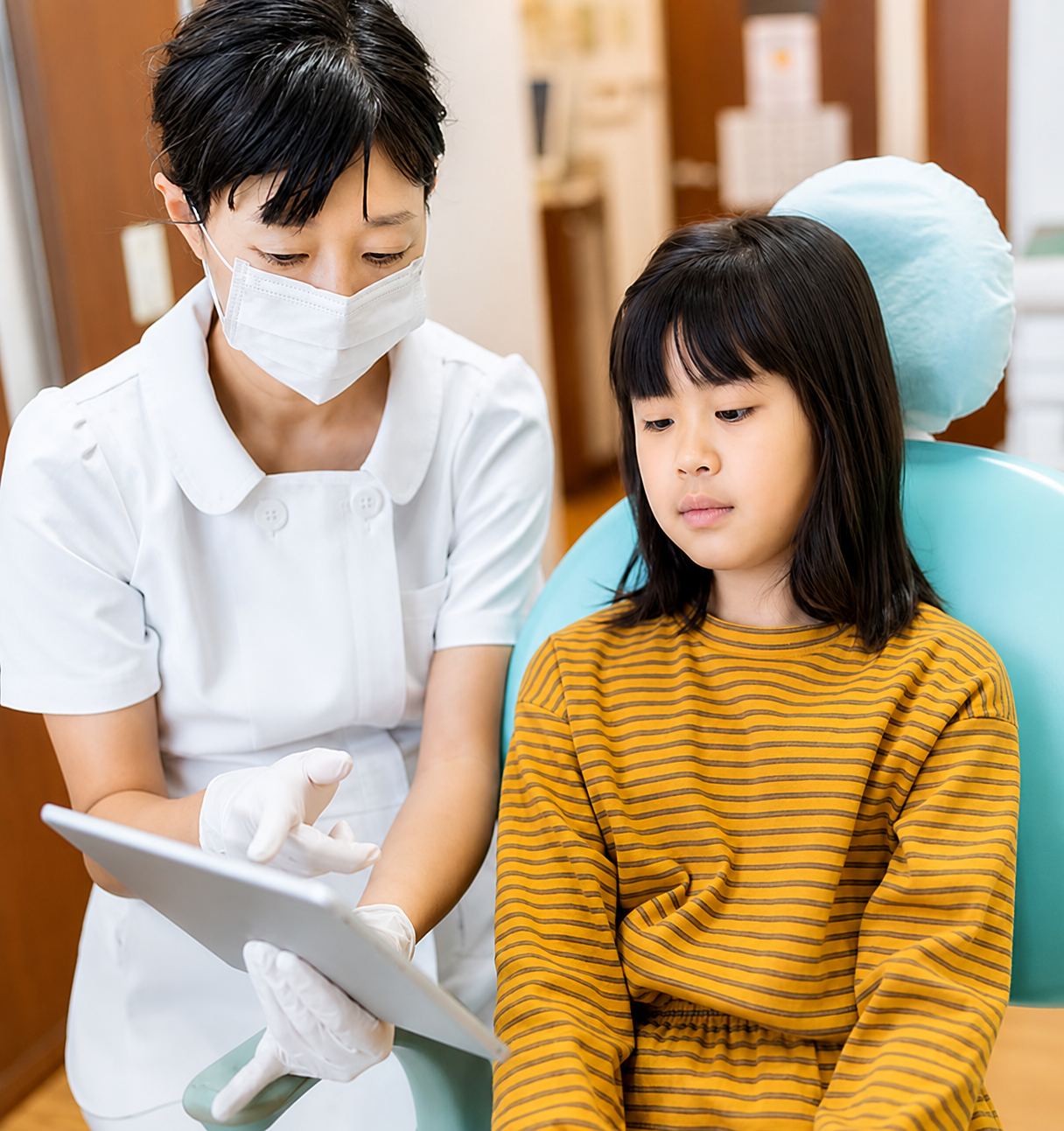Dental assistant talking to young kid