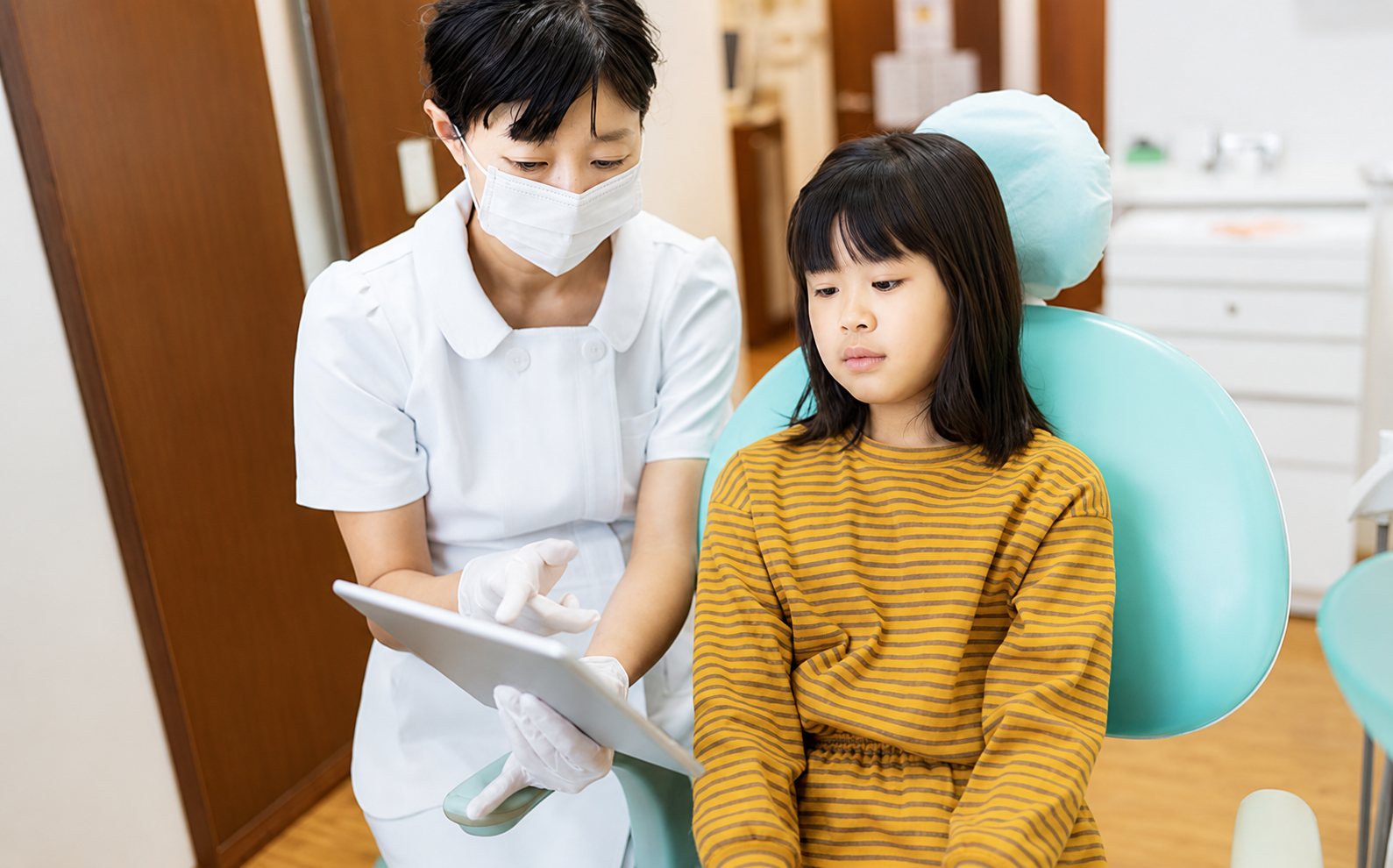 Dentist talking to young patient